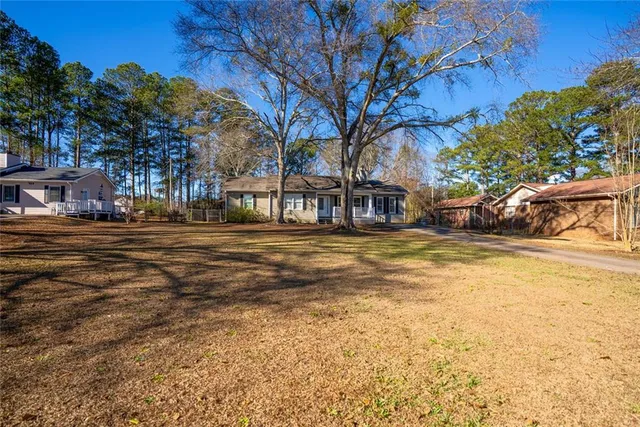 a view of a backyard with table and chairs and wooden fence