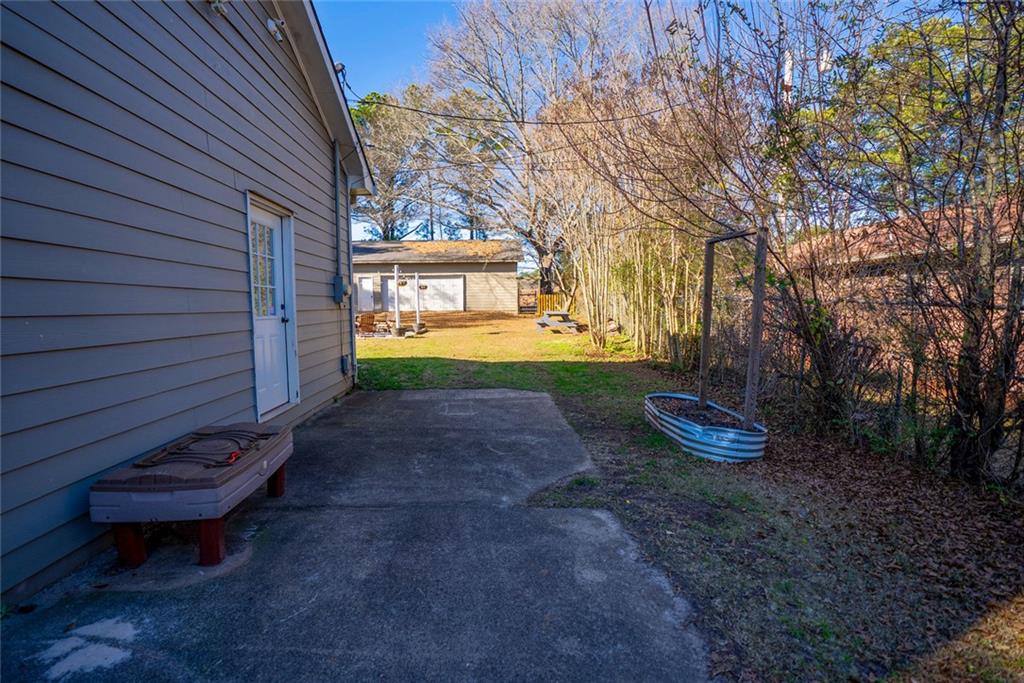 707 Reese Street Monroe, GA 30655 - Photo 39 of 61 a view of a backyard with table and chairs and wooden fence