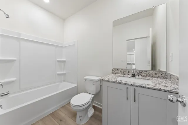 a bathroom with a granite countertop toilet a sink and a bathtub
