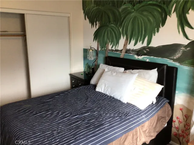 a bedroom with a bed and a potted plant