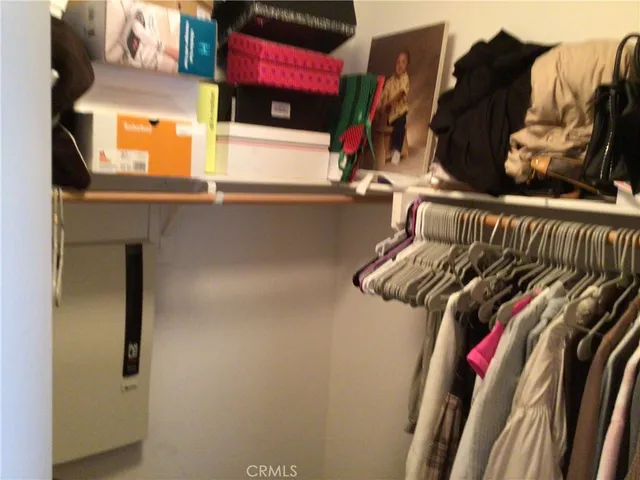 a view of walk in closet with clothes