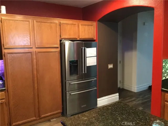 a kitchen with metallic refrigerator and cabinets