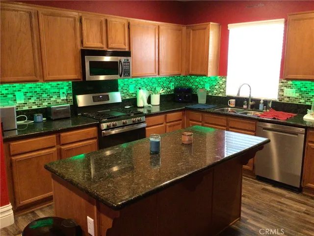 a kitchen with stainless steel appliances granite countertop a sink a counter top space and cabinets