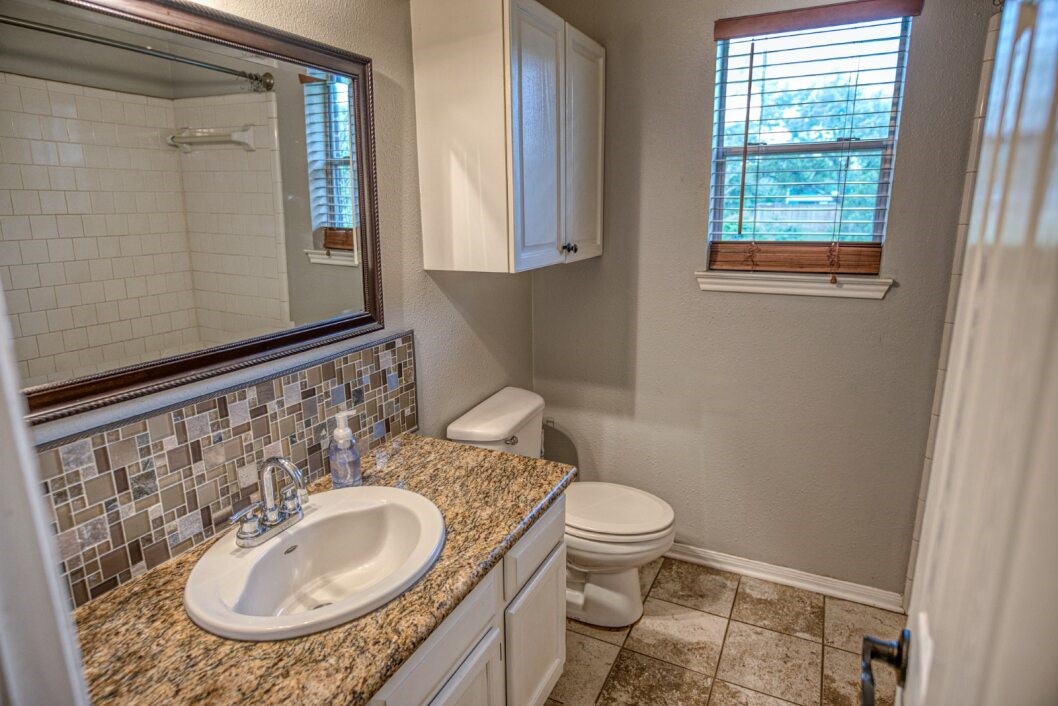 308 County Road 893B Angleton, TX 77515 - Photo 26 of 41 a bathroom with a granite countertop sink and a mirror