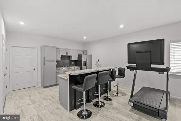 a kitchen with stainless steel appliances kitchen island granite countertop a dining table chairs and granite counter tops