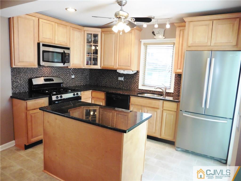 113 Highfield Road Colonia, NJ 07067 - Photo 11 of 25 a kitchen with stainless steel appliances granite countertop a sink stove and refrigerator