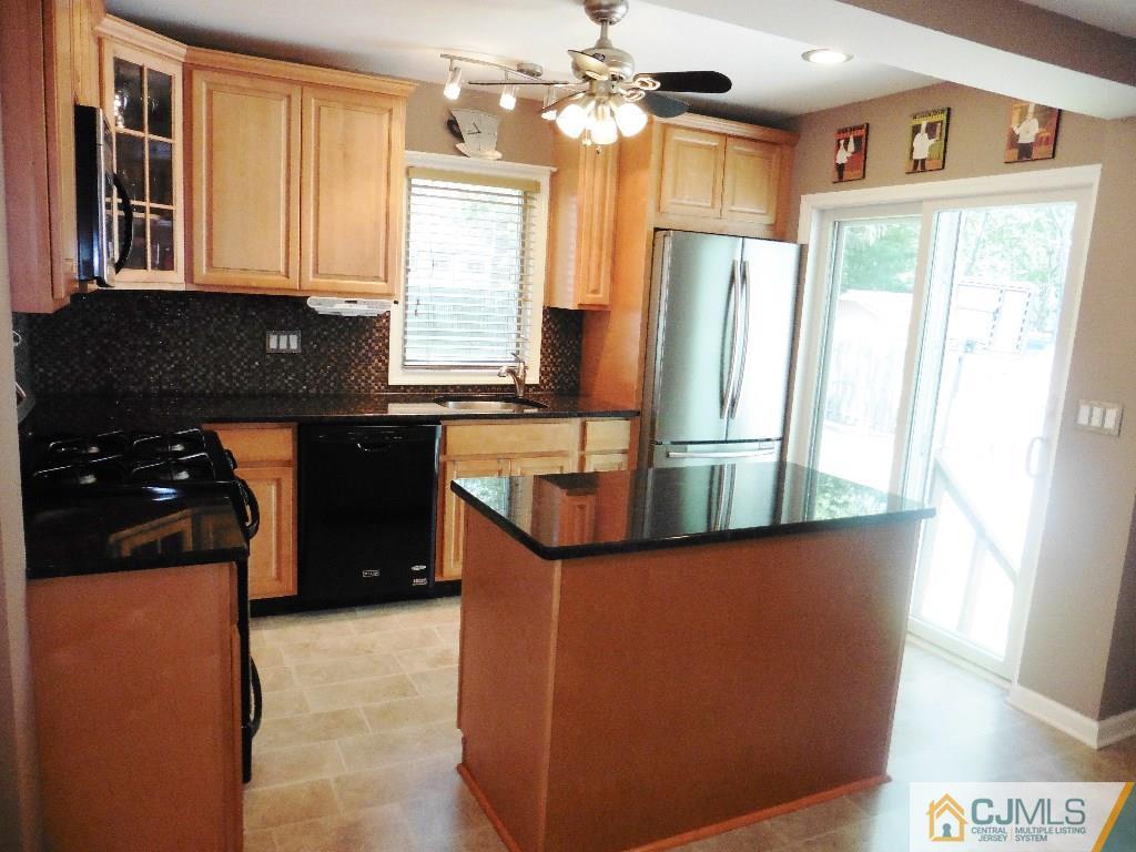 113 Highfield Road Colonia, NJ 07067 - Photo 12 of 25 a kitchen with stainless steel appliances granite countertop a refrigerator a sink a stove and a refrigerator