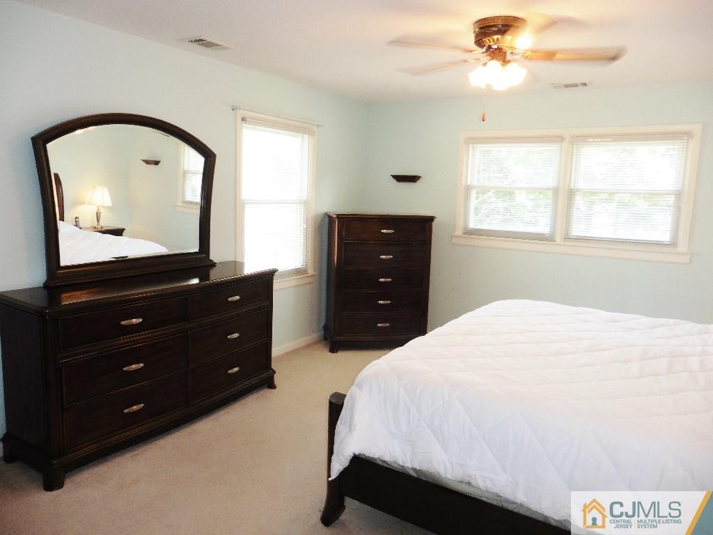 113 Highfield Road Colonia, NJ 07067 - Photo 18 of 25 a bedroom with a bed and a mirror on dresser