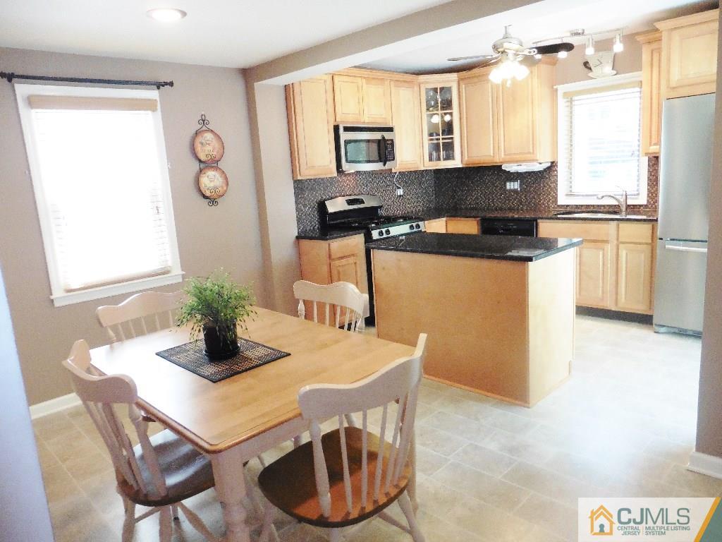 113 Highfield Road Colonia, NJ 07067 - Photo 10 of 25 a kitchen with a table chairs and a refrigerator