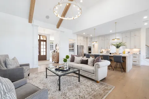 a large white kitchen with cabinets a sink a window and stainless steel appliances