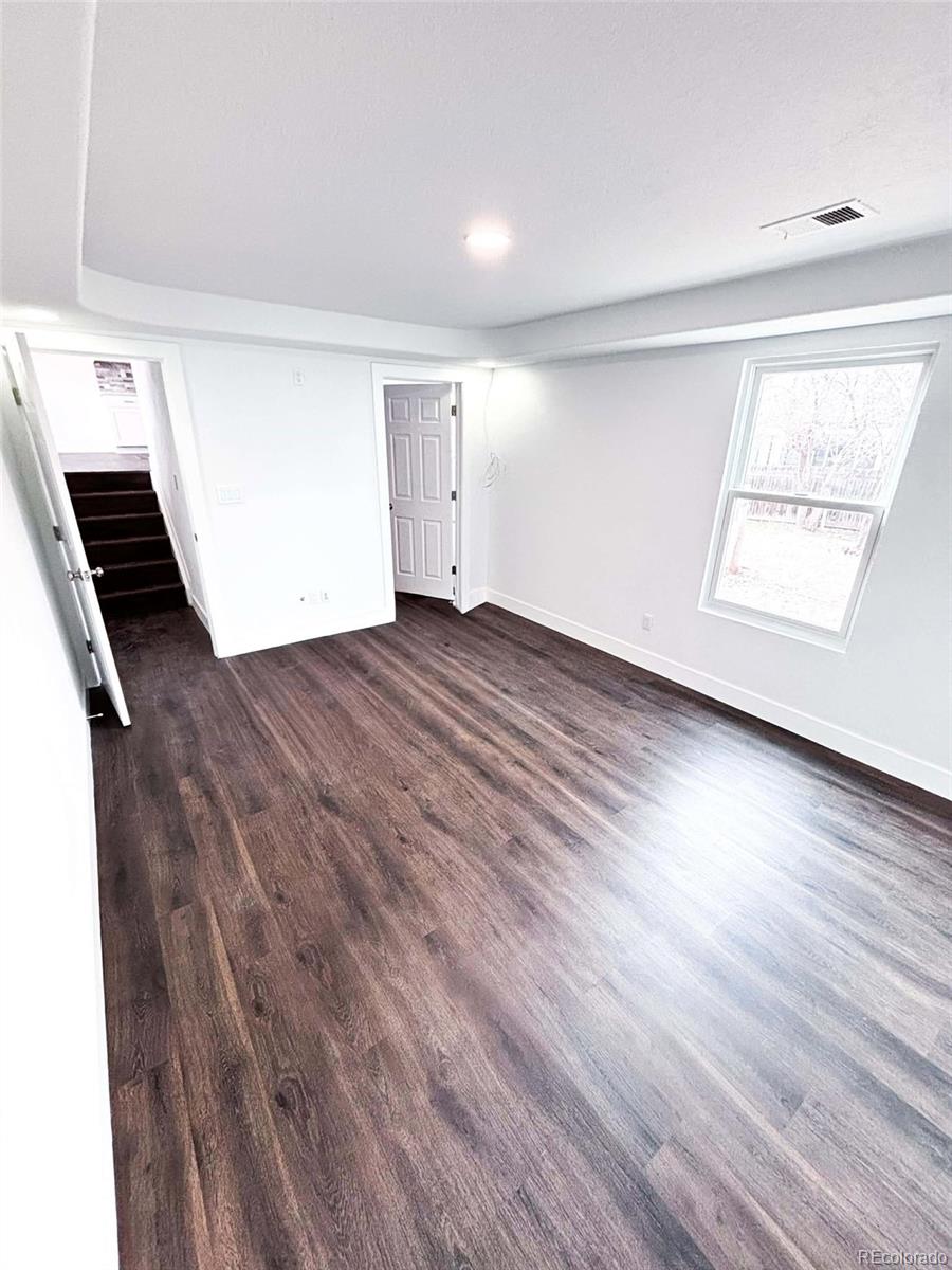 4295 Genoa Street Denver, CO 80249 - Photo 11 of 28 an empty room with wooden floor and windows