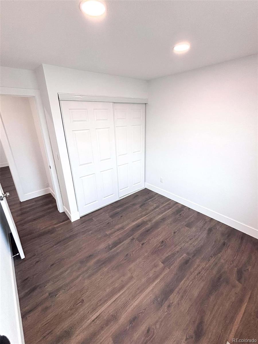 4295 Genoa Street Denver, CO 80249 - Photo 12 of 28 an empty room with wooden floor and window