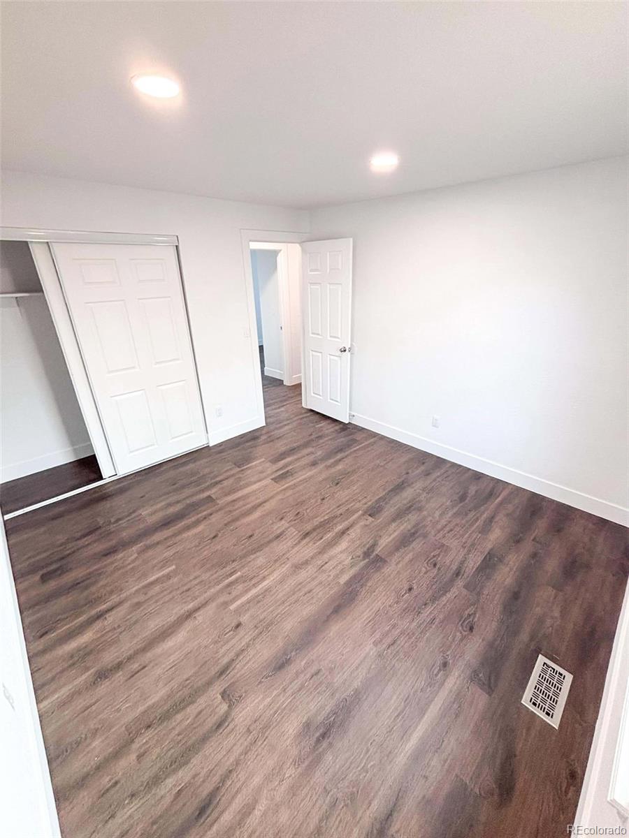 4295 Genoa Street Denver, CO 80249 - Photo 13 of 28 an empty room with wooden floor