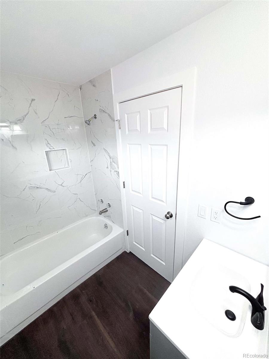 4295 Genoa Street Denver, CO 80249 - Photo 21 of 28 a bathroom with a bathtub and a shower