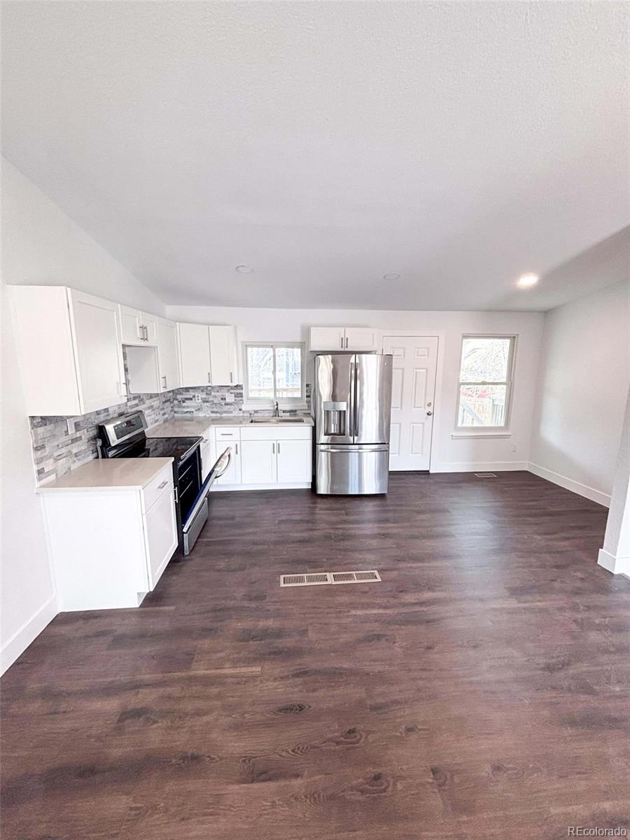 4295 Genoa Street Denver, CO 80249 - Photo 3 of 28 a view of kitchen and hall with wooden floor