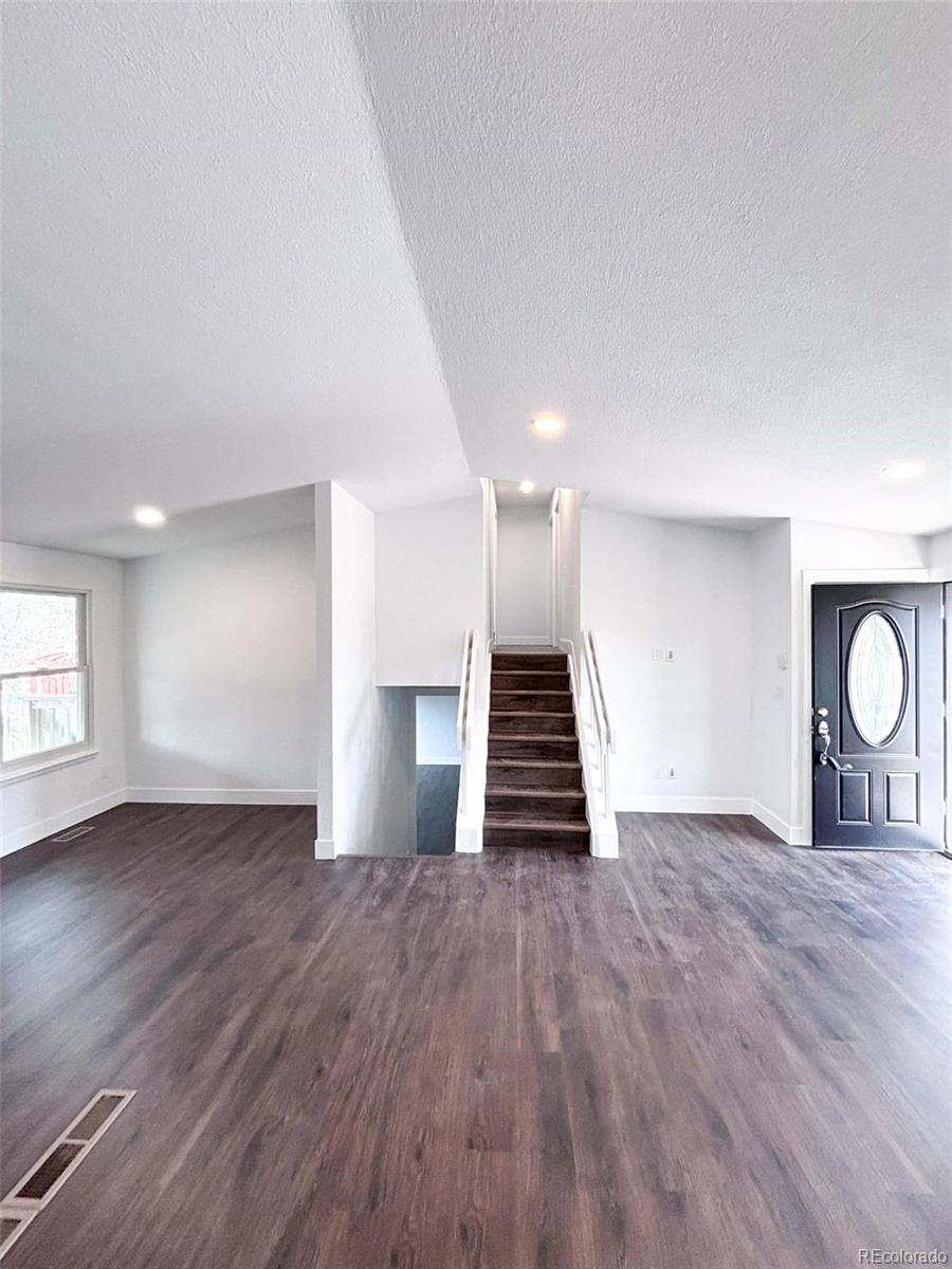 4295 Genoa Street Denver, CO 80249 - Photo 8 of 28 a view of an empty room with wooden floor and window