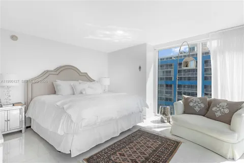 a bedroom with a bed couch and a window