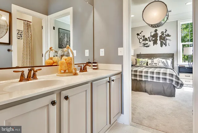 a en suite bathroom with a double vanity sink and a mirror