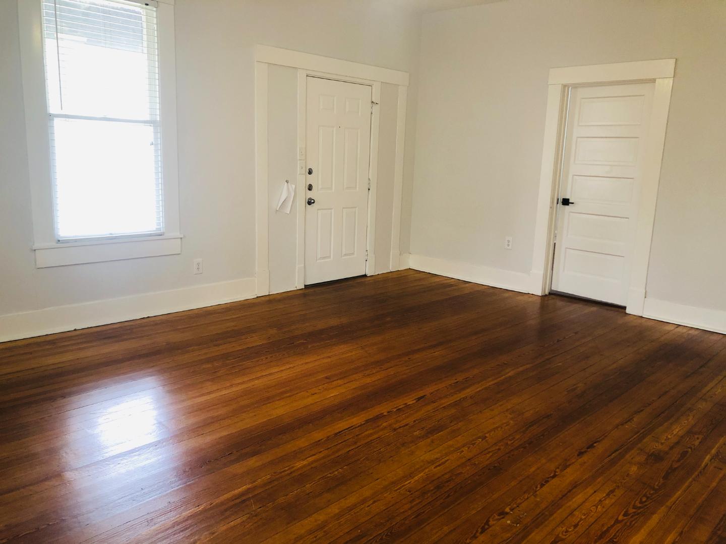 207 West 39th Street, Unit MAIN Austin, TX 78751 - Photo 5 of 7 Warm hardwood floors and abundant natural light create an inviting atmosphere in this versatile space.
