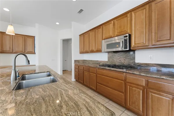 an empty room with wooden floor cabinet and windows