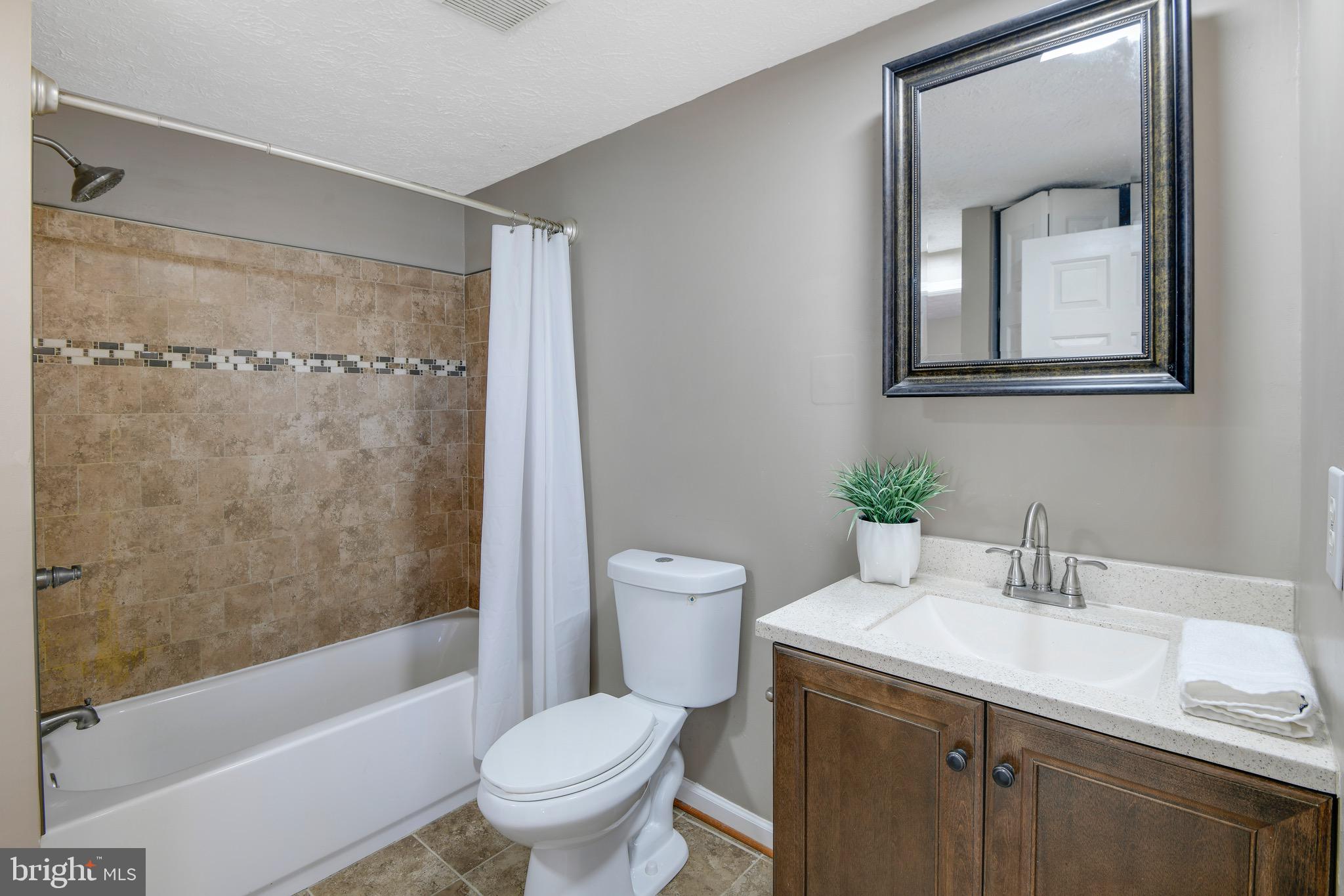 7025 Hames Court Frederick, MD 21703 - Photo 13 of 22 a bathroom with a granite countertop sink toilet and shower