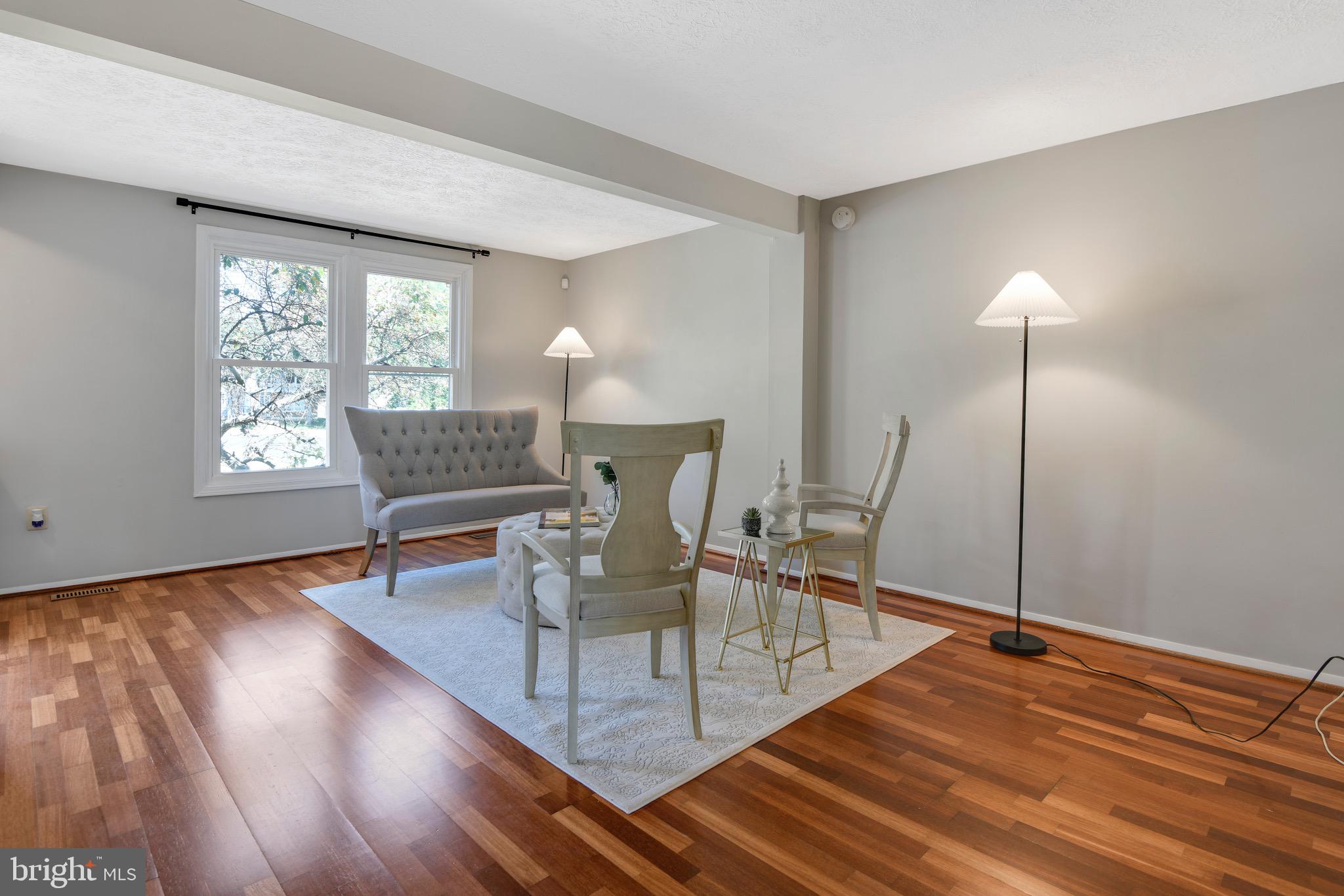 7025 Hames Court Frederick, MD 21703 - Photo 3 of 22 a dining room with wooden floor a glass table and chairs