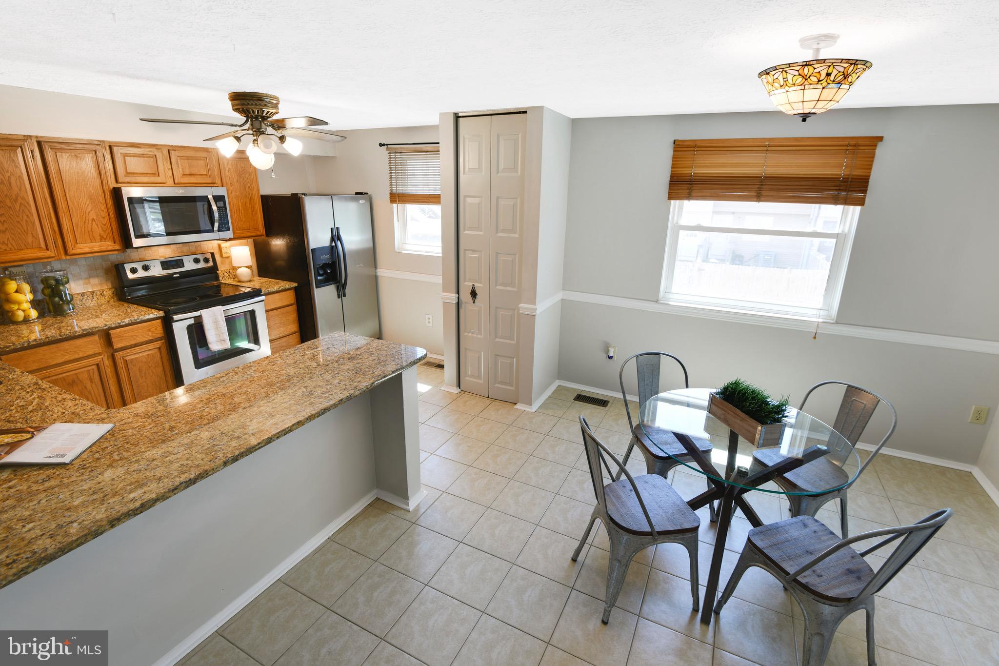 7025 Hames Court Frederick, MD 21703 - Photo 7 of 22 a kitchen with stainless steel appliances granite countertop a sink and a refrigerator
