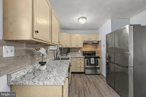 a kitchen with stainless steel appliances granite countertop a refrigerator stove and sink