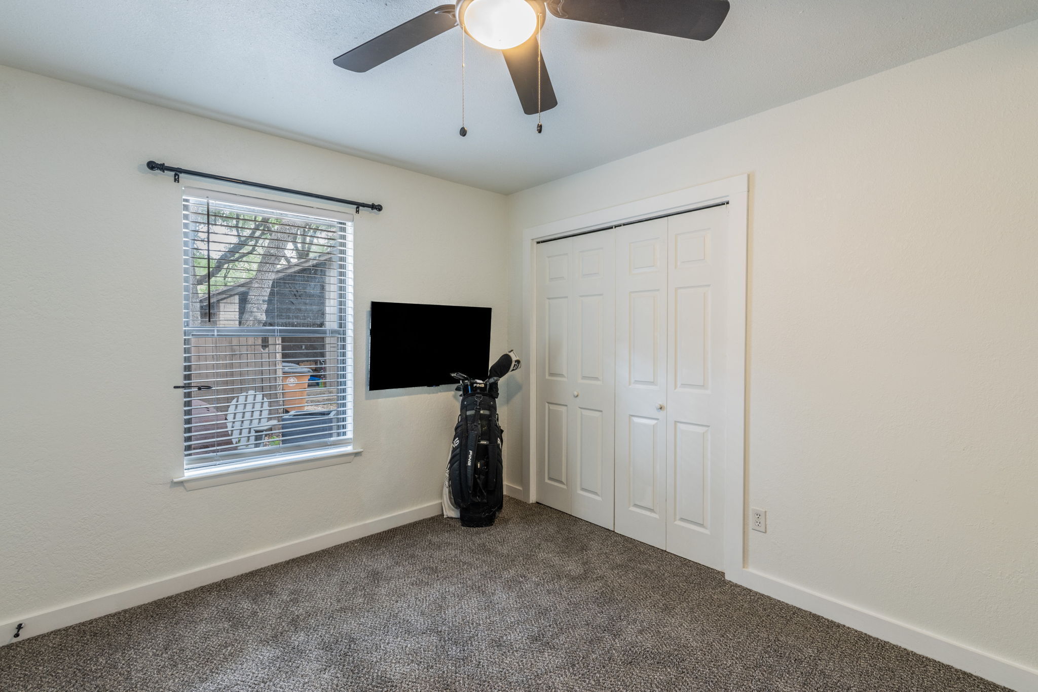 1008 Milford Way Austin, TX 78745 - Photo 36 of 40 Carpeted room featuring a ceiling fan with integrated lighting, a window with horizontal blinds, and a built-in closet with bifold doors