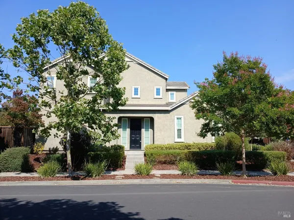 a front view of a house with a yard and potted plants