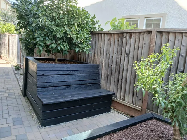 a wooden bench sitting in front of a wooden fence