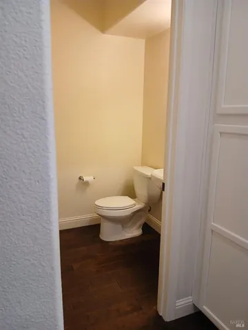 a white toilet sitting next to a white sink and vanity