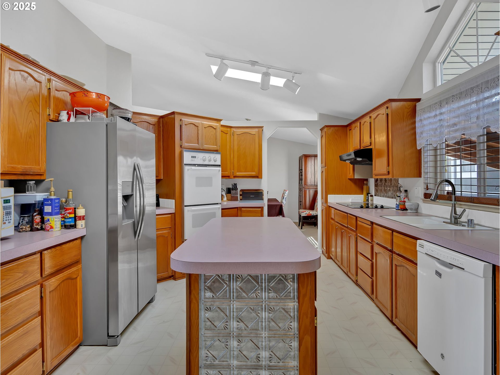 1819 Southeast Orient Drive, Unit 8 Gresham, OR 97080 - Photo 12 of 30 a kitchen with stainless steel appliances kitchen island granite countertop a refrigerator a stove a sink a dining table and chairs with wooden floor