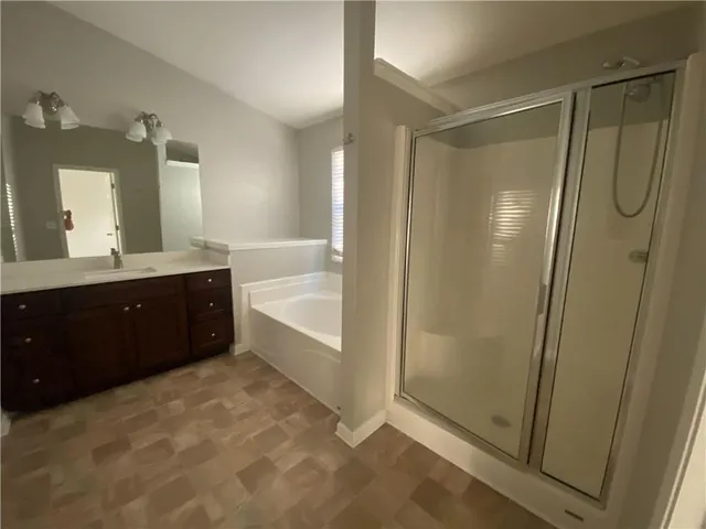a bathroom with a tub sink shower and mirror