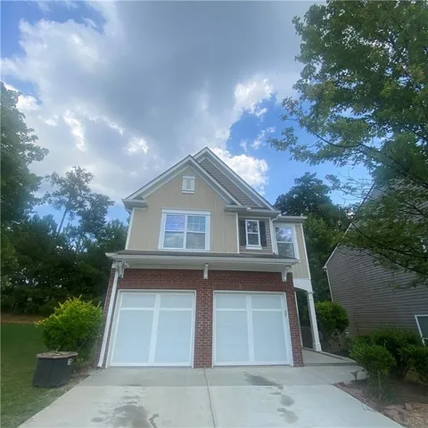 a front view of a house with yard garage and trees