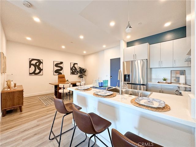 a kitchen with a dining table chairs and white cabinets