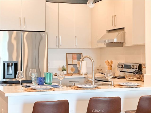 a kitchen with stainless steel appliances kitchen island granite countertop a dining table and chairs
