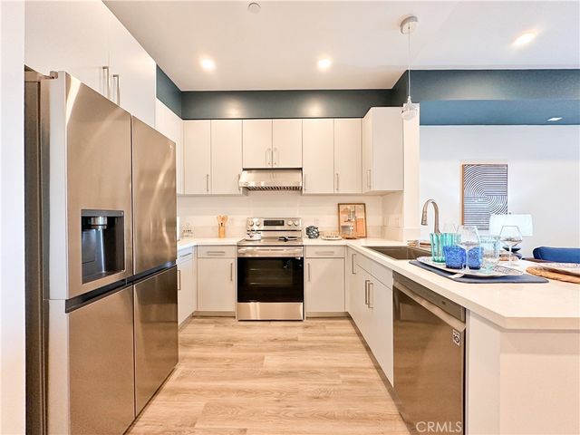 a kitchen with stainless steel appliances granite countertop a refrigerator a stove a sink and a microwave