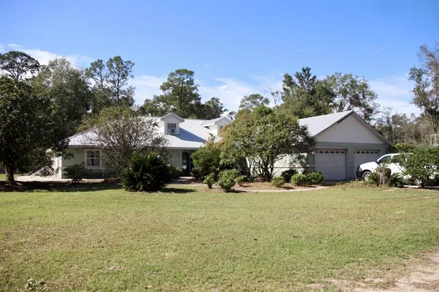 a view of a house with yard and garage