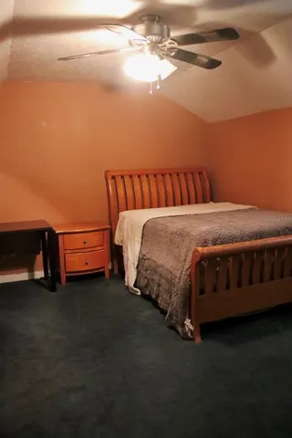 a bed sitting in a bedroom next to a lamp