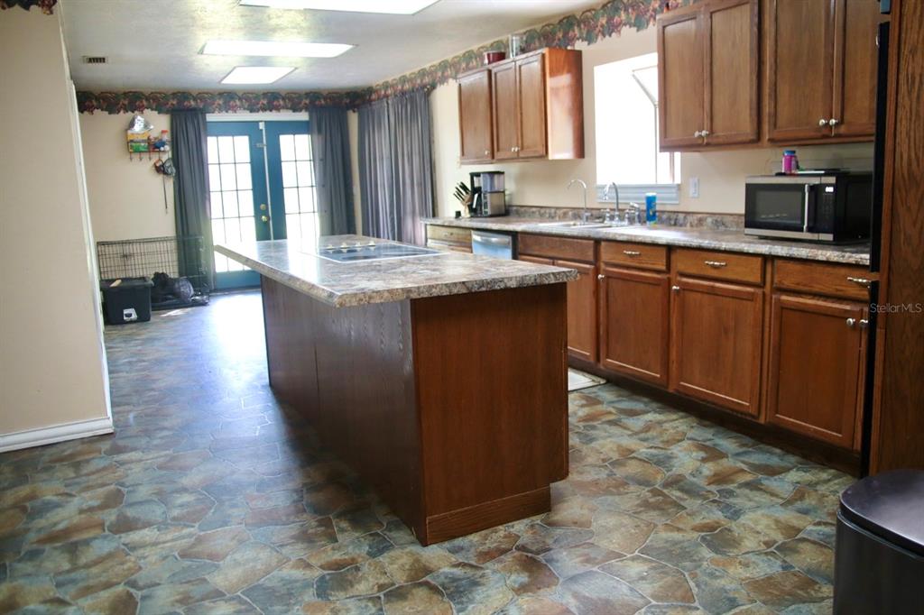 786 Southwest Bozeman Court Lake City, FL 32024 - Photo 8 of 32 a kitchen with stainless steel appliances granite countertop a stove a sink and a microwave