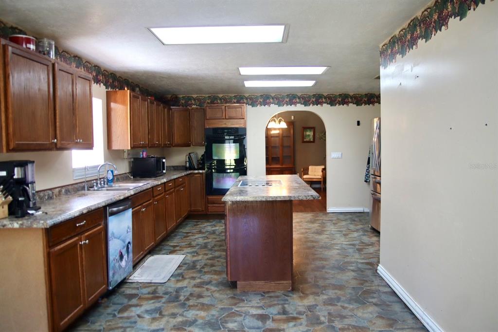 786 Southwest Bozeman Court Lake City, FL 32024 - Photo 9 of 32 a kitchen with stainless steel appliances granite countertop a stove a sink and a refrigerator