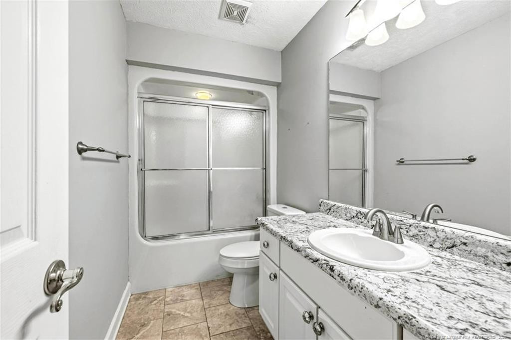 403 Lionshead Road Fayetteville, NC 28311 - Photo 31 of 49 a bathroom with a granite countertop sink a toilet a mirror and shower