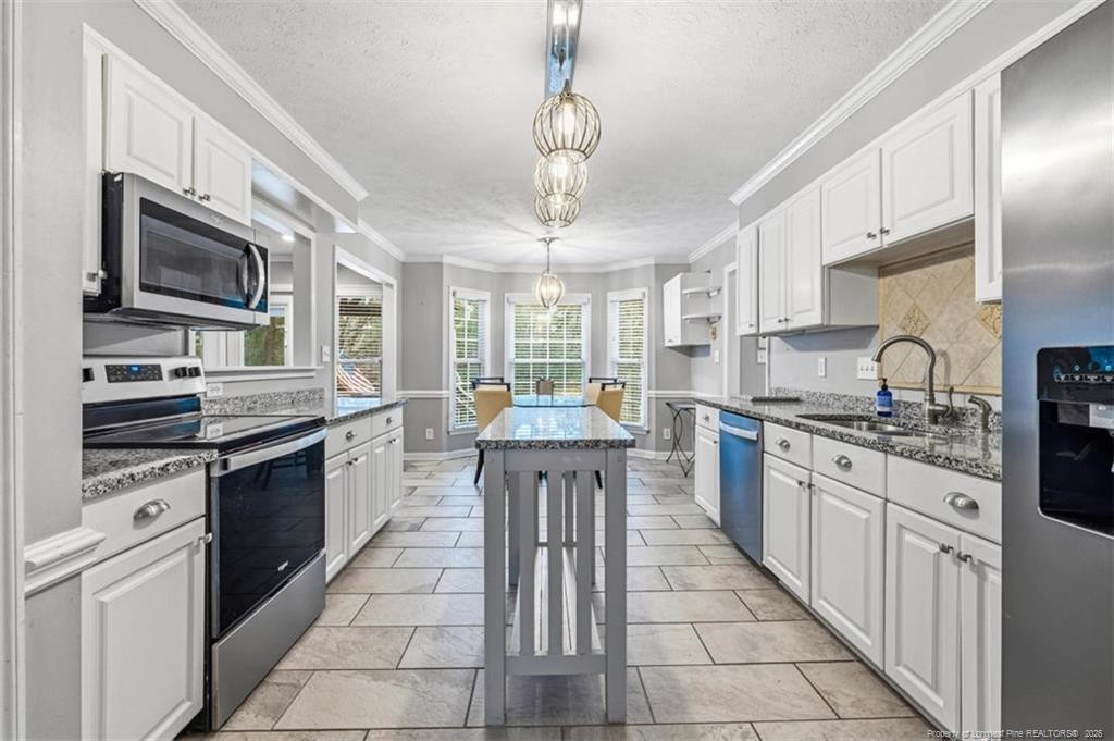 403 Lionshead Road Fayetteville, NC 28311 - Photo 6 of 49 a large kitchen with stainless steel appliances granite countertop a stove top oven a sink dishwasher a dining table and chairs with wooden floor