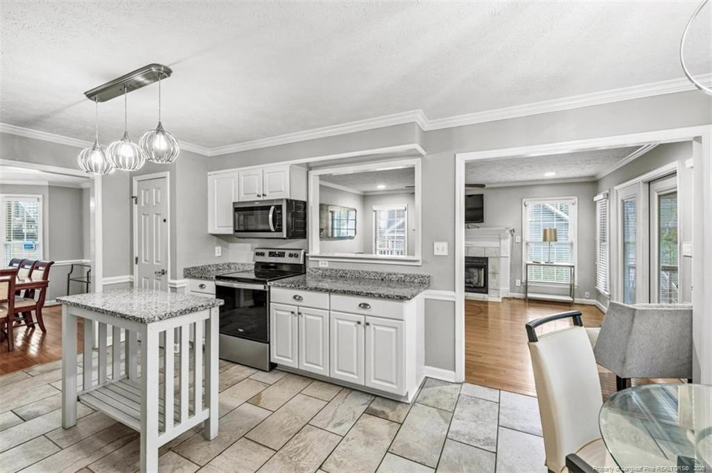 403 Lionshead Road Fayetteville, NC 28311 - Photo 8 of 49 a large kitchen with cabinets chairs and stainless steel appliances
