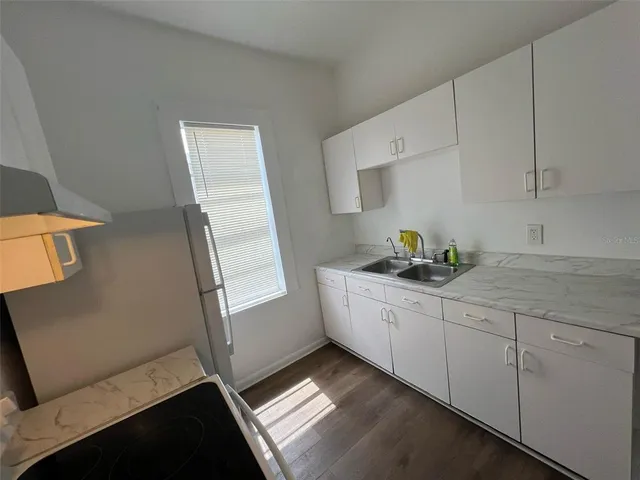 a kitchen with granite countertop white cabinets and white appliances