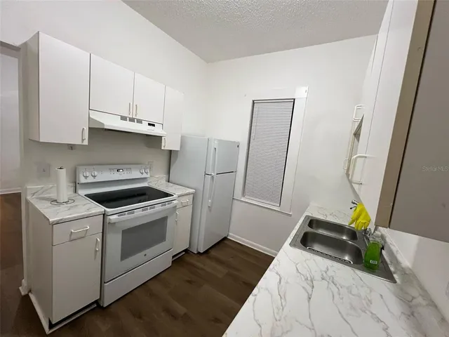 a kitchen with granite countertop a sink and cabinets