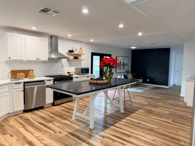 a kitchen with granite countertop a stove a sink and a refrigerator