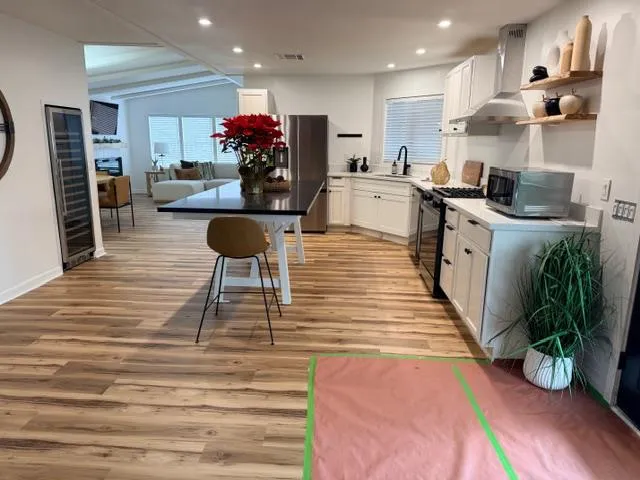 a kitchen with stainless steel appliances kitchen island granite countertop a stove and a refrigerator