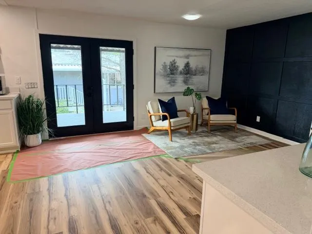 a view of a livingroom with wooden floor and furniture